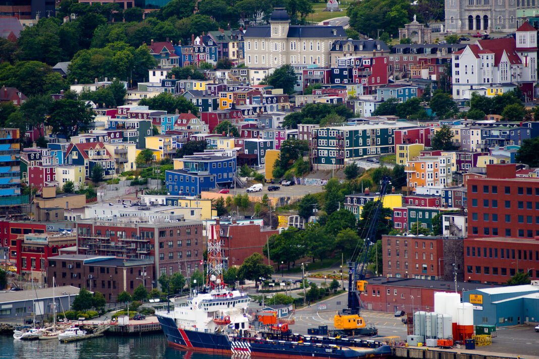 Best Places to Live in Newfoundland and Labrador 2026: St. John’s, Corner Brook, and the Outports Jelly Bean Row colourful row houses on the hillside above the harbour in downtown St Johns Newfoundland and Labrador