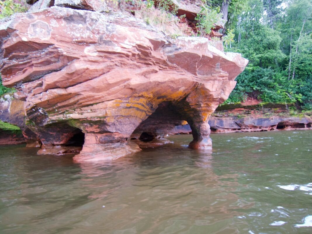 Outdoor Activities in Wisconsin 2026: Apostle Islands, Driftless Trails, and Great Lakes Recreation Sea kayaking past red sandstone sea caves at Apostle Islands National Lakeshore on Lake Superior, Wisconsin