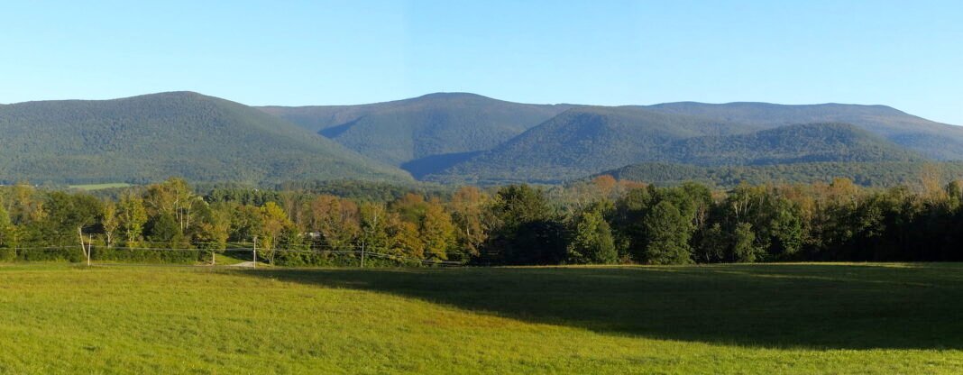 Outdoor Activities in Massachusetts 2026: Trails, Beaches, and the Berkshire Wilderness Mount Greylock and the forested Berkshire Hills rising above a green meadow in western Massachusetts