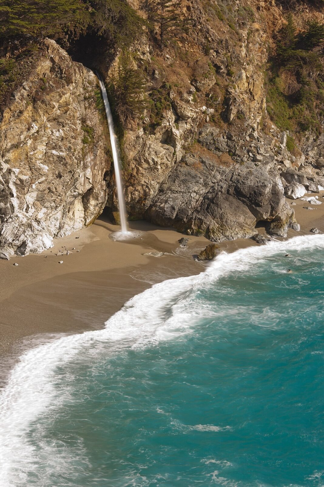 Best Places to Visit in California: The Ultimate Travel Guide McWay Falls cascading onto the sandy beach at McWay Cove in Big Sur California May 2011