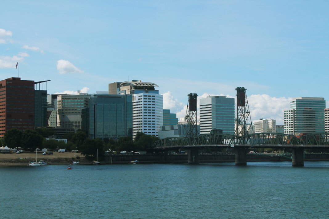 Cost of Living in Oregon 2026: No Sales Tax, Rising Rents, and the Portland Premium Portland Oregon skyline with Mount Hood in background Columbia River