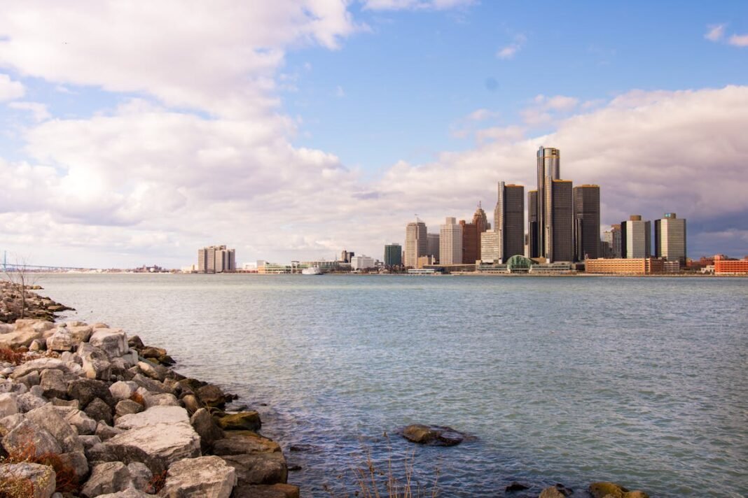 Moving to Michigan in 2026: Complete Relocation Guide Detroit Michigan skyline waterfront across the Detroit River downtown buildings