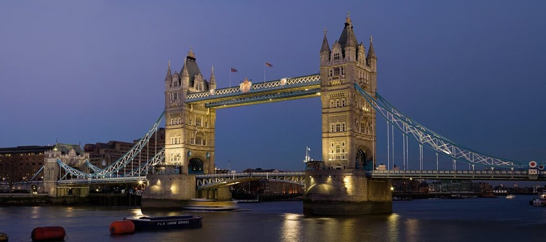 Budget Travel in the UK: See Britain Without Spending a Fortune Tower Bridge Thames River London England dusk illuminated budget travel United Kingdom guide