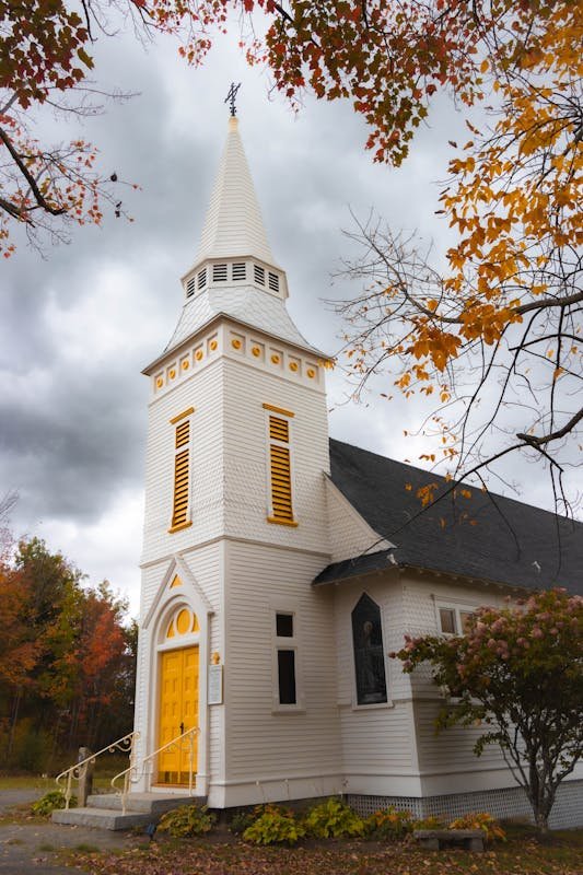 Moving to Vermont in 2026: Complete Relocation Guide White church steeple in New England village autumn leaves Vermont countryside