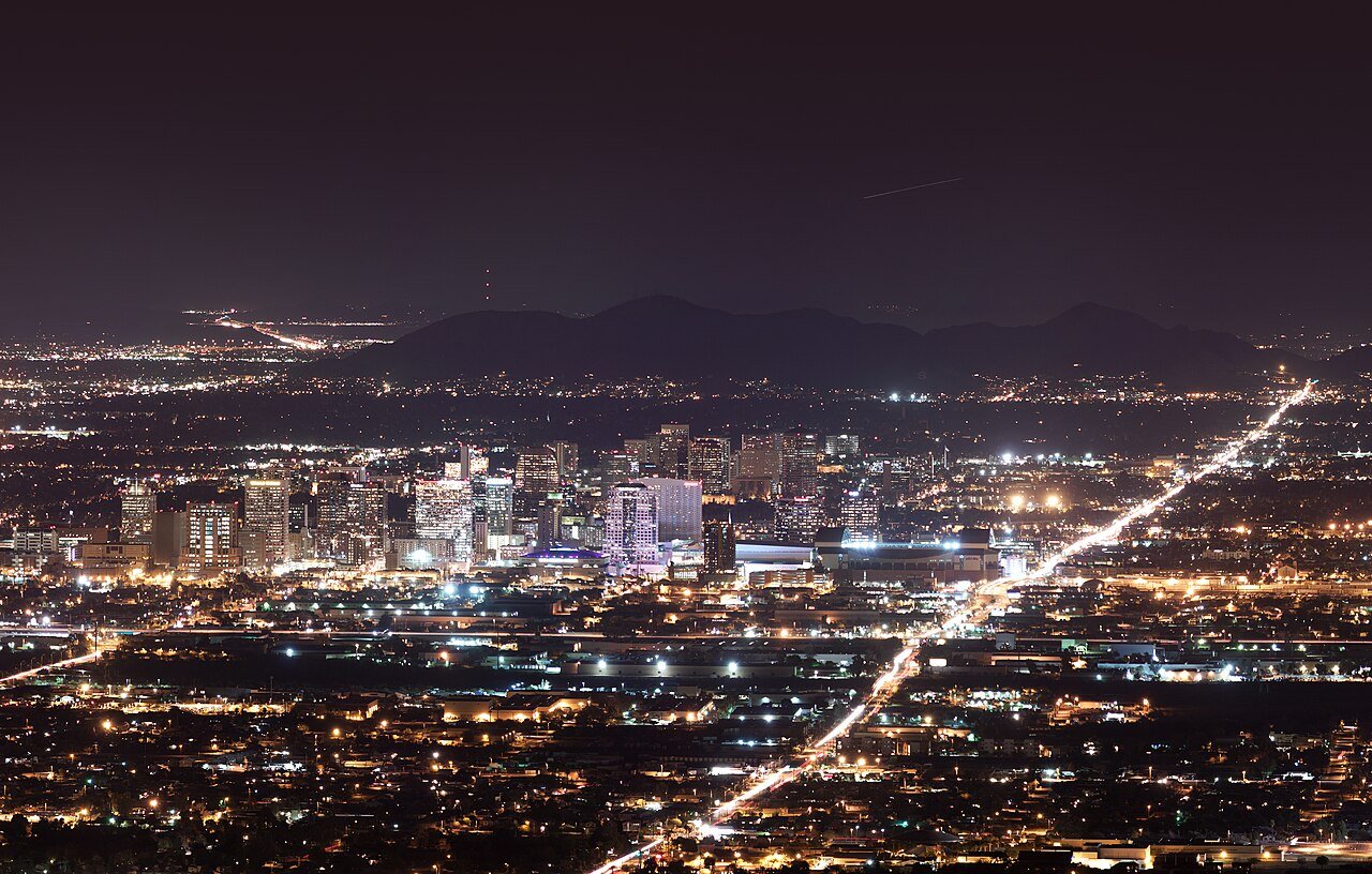Downtown Phoenix Arizona skyline illuminated at night with city lights spreading across the Valley of the Sun