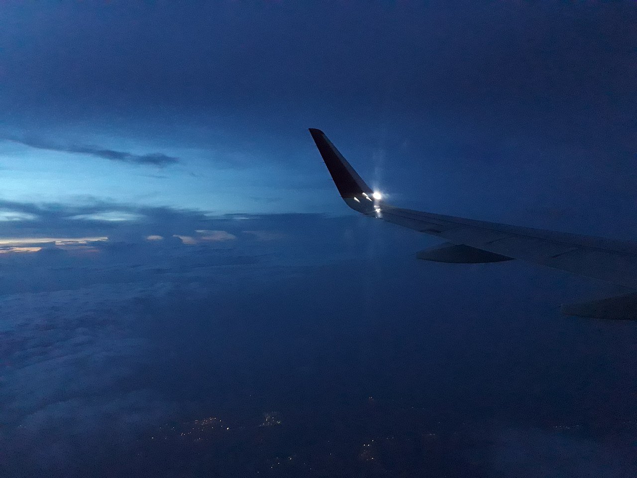 View from airplane window above clouds — finding cheap flights through the right search tools and booking timing can save hundreds of dollars on every international trip