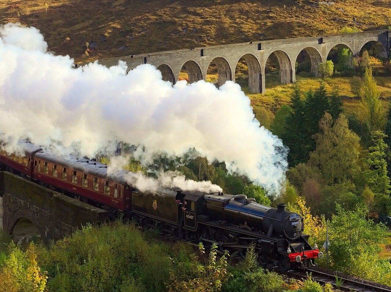 The Jacobite steam train crossing Glenfinnan Viaduct in the Scottish Highlands — one of the world's most scenic rail journeys