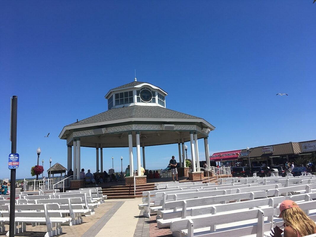 Best Places to Visit in Delaware: Beach, History, and the Brandywine Valley Rehoboth Beach bandstand on the boardwalk under blue sky with rows of white benches in summer, Delaware