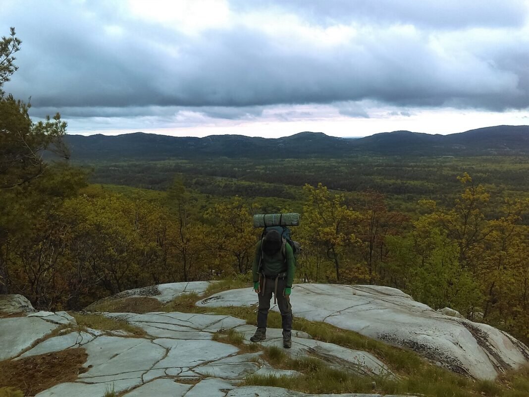 Outdoor Activities in Ontario 2026: Algonquin, Niagara, and the Great Lakes Backpacker on white quartzite ridge of the La Cloche Silhouette Trail overlooking the La Cloche Mountains in Killarney Provincial Park Ontario Canada