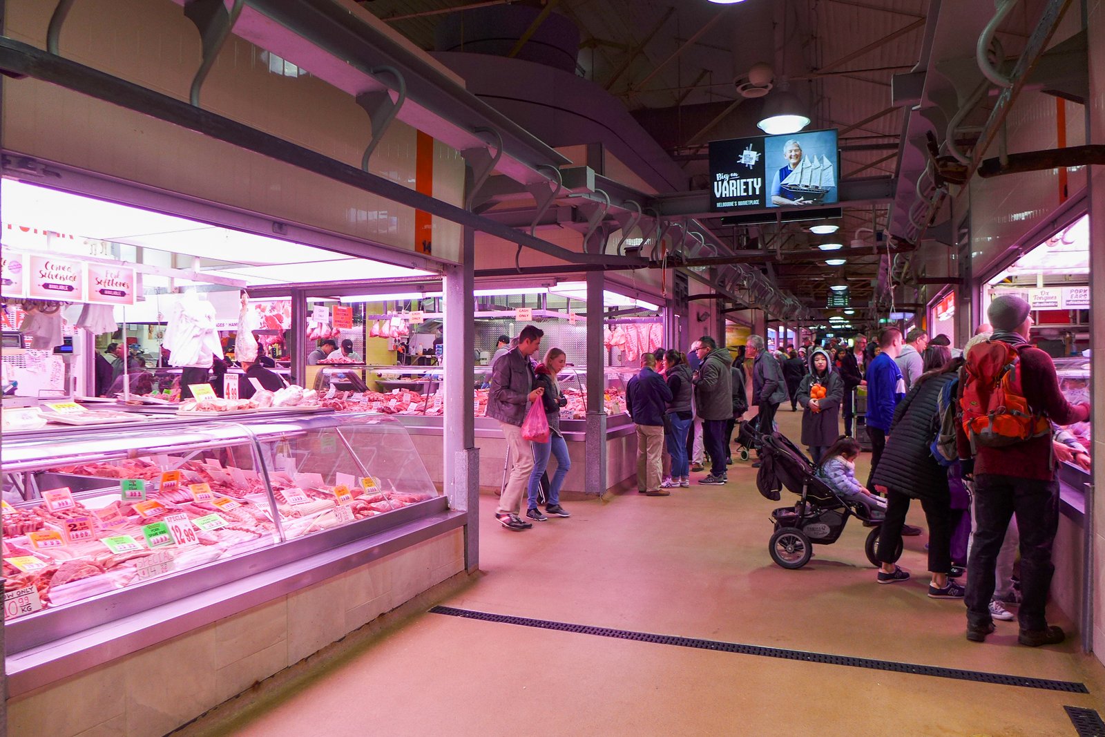 Shoppers browsing the deli and meat hall counters inside Queen Victoria Market in Melbourne, the city's main fresh-food market