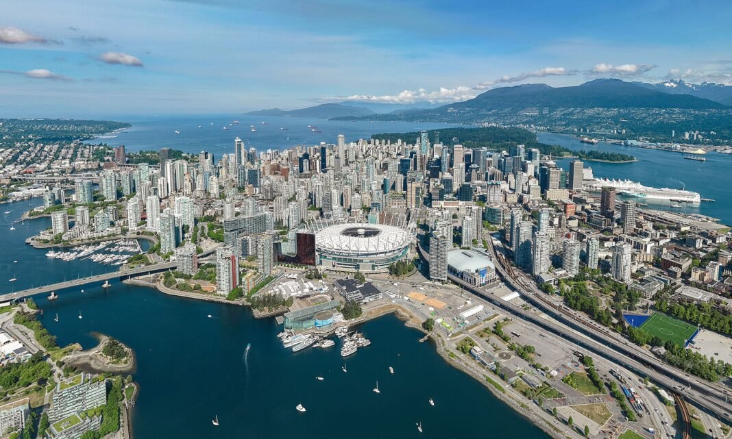 Vancouver Travel Guide: Mountains, Ocean, and Urban Cool Aerial view of the Vancouver downtown skyline on its peninsula with False Creek and Burrard Inlet water and the North Shore mountains behind British Columbia Canada