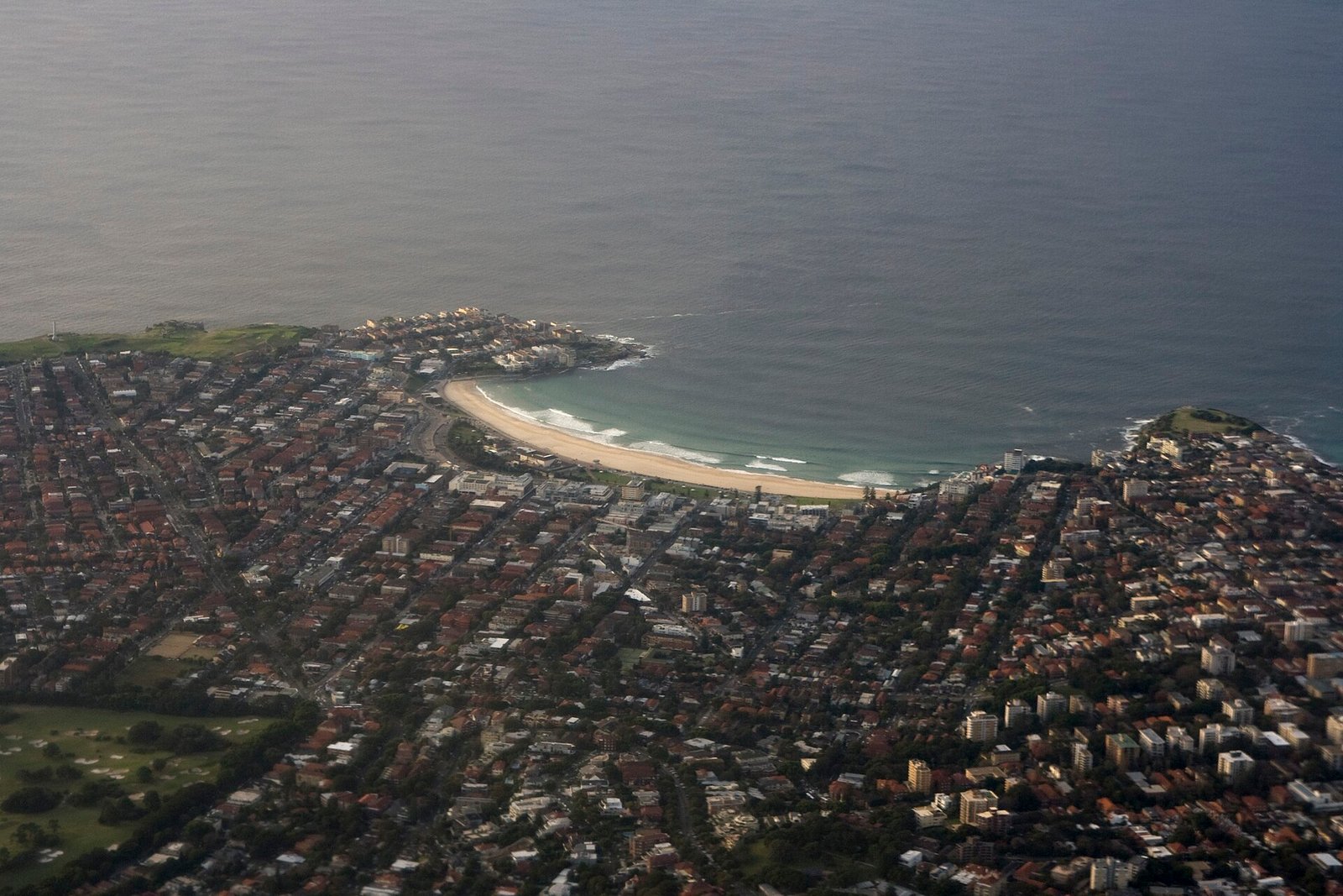 Bondi Beach aerial view, Sydney — the famous crescent of golden sand with the Bondi Icebergs ocean pool on the rocky southern headland