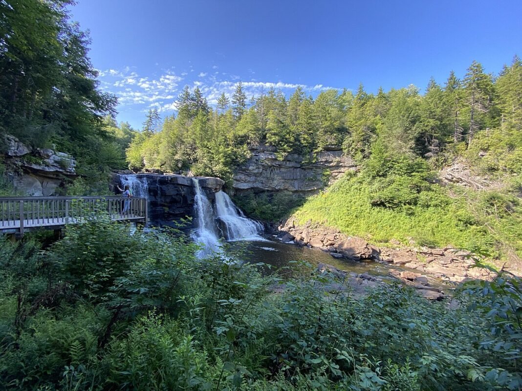 Outdoor Activities in West Virginia 2026: Whitewater, Climbing, and Appalachian Wilderness Blackwater Falls cascading over sandstone ledge in Blackwater Falls State Park West Virginia with summer forest and viewing boardwalk