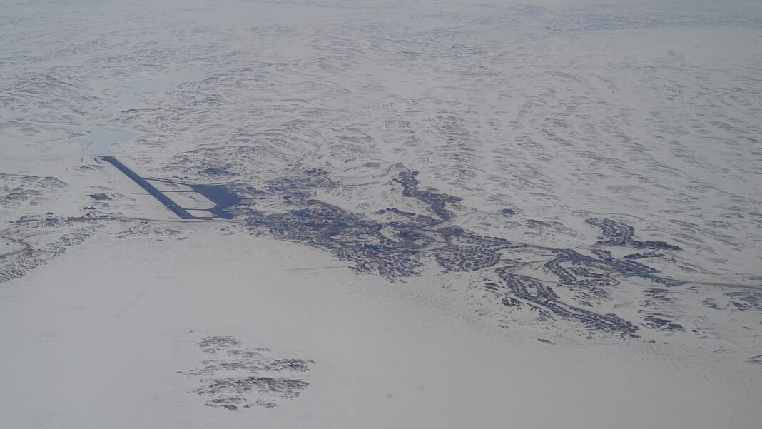 Nunavut Communities Guide 2026: Iqaluit, Rankin Inlet, Cambridge Bay, and Life in the Arctic Aerial view of Iqaluit, the capital of Nunavut, on the snow-covered Arctic tundra beside Frobisher Bay on Baffin Island