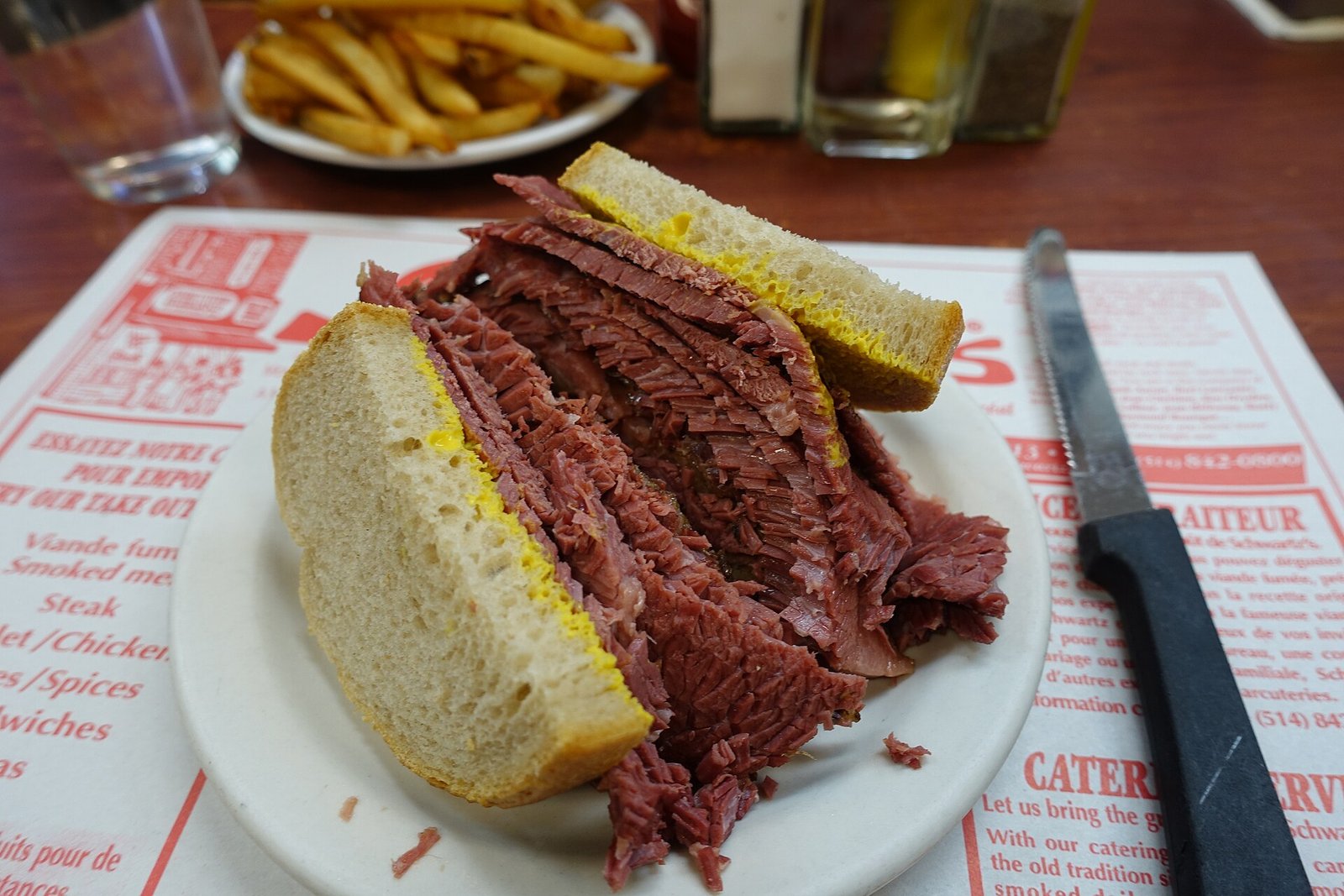 Montreal smoked meat sandwich on rye bread with yellow mustard — the defining dish of Montreal's Jewish deli tradition, served at Schwartz's Hebrew Delicatessen on Boulevard Saint-Laurent