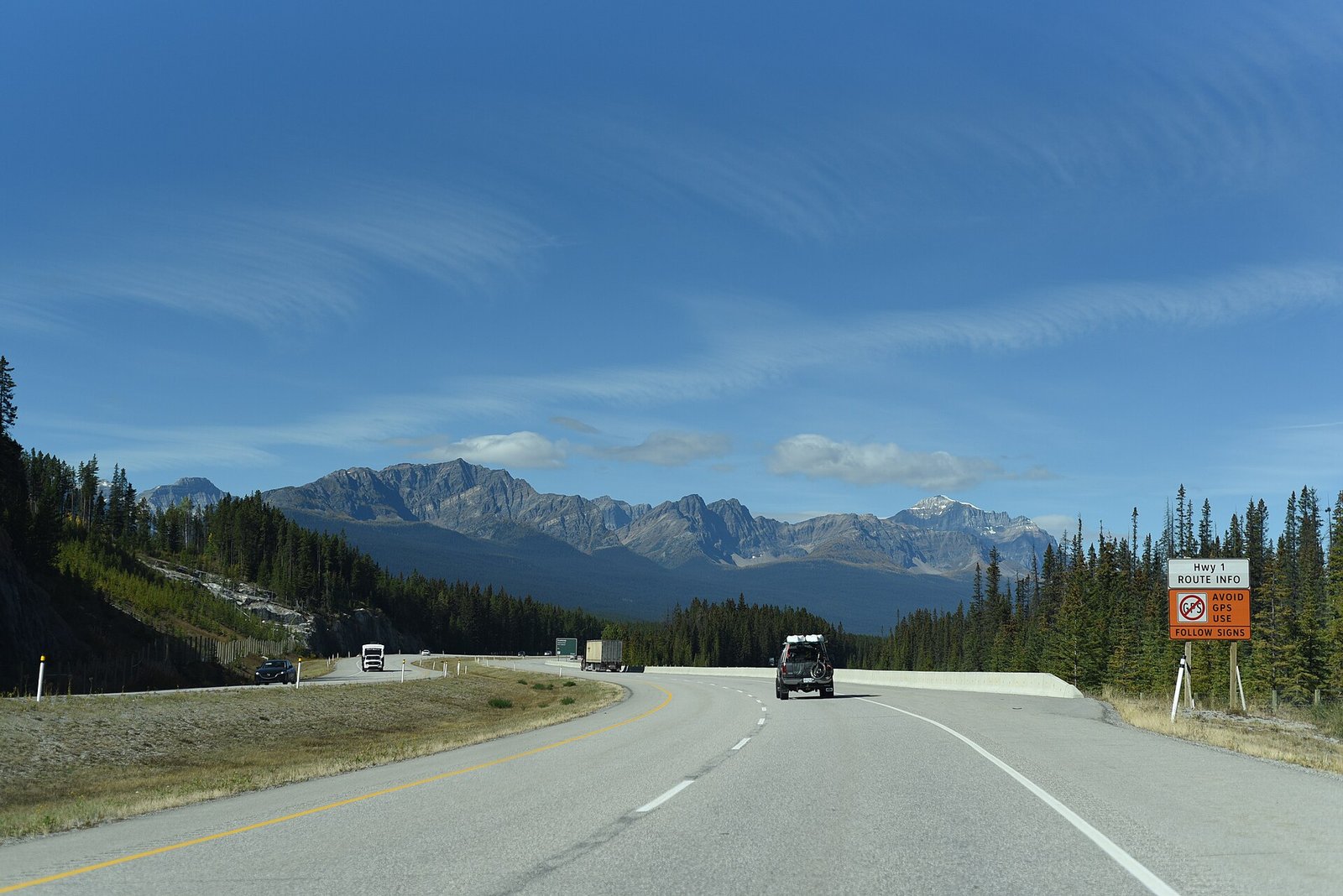 The Trans-Canada Highway (Highway 1) sweeping through the Canadian Rockies in Banff National Park, Alberta, under a clear blue sky